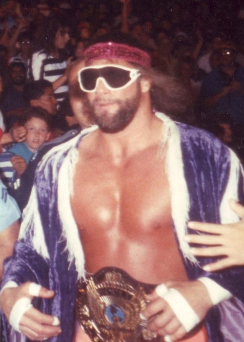 Professional wrestler Randy 'Macho Man' Savage, wearing the WWF Championship and running to the ring